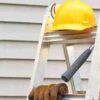 Workplace ladders with a workers PPE helmet, gloves and hammer