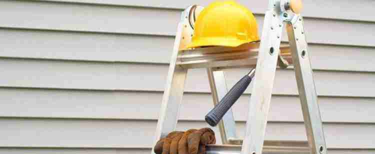 Workplace ladders with a workers PPE helmet, gloves and hammer